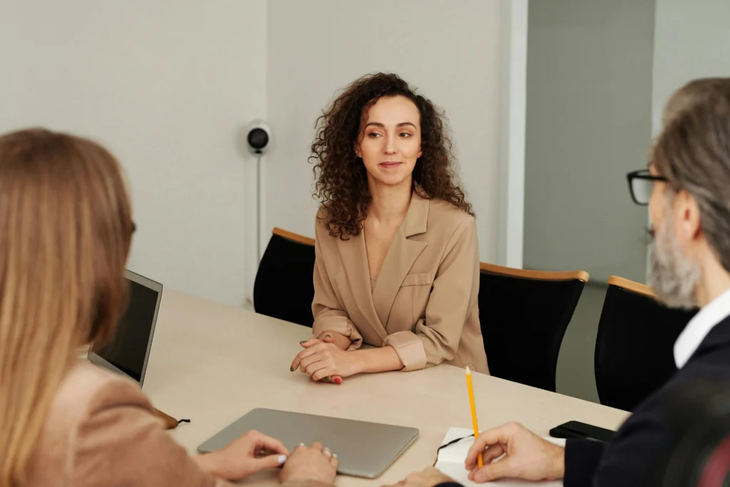 Professional woman engaged in a discussion during a meeting, symbolizing the strategic planning and discussions required to earn PMP certification.
